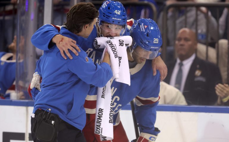 Oct 20, 2025; New York, New York, USA; New York Rangers center Noah Laba (42) is helped off the ice after taking a puck to the mouth during the second period against the Minnesota Wild at Madison Square Garden. Mandatory Credit: Brad Penner-Imagn Images