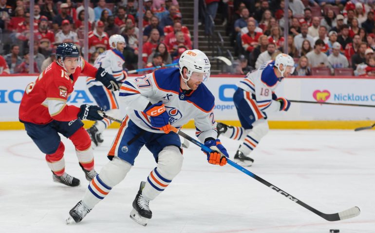 Nov 22, 2025; Sunrise, Florida, USA; Edmonton Oilers defenseman Brett Kulak (27) moves the puck against Florida Panthers center Anton Lundell (15) during the first period at Amerant Bank Arena. Mandatory Credit: Sam Navarro-Imagn Images
