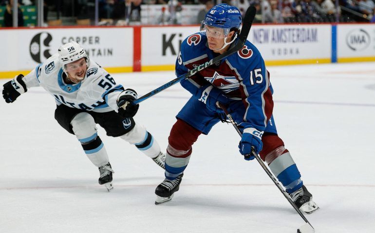 Sep 21, 2025; Denver, Colorado, USA; Colorado Avalanche defenseman Jack Ahcan (15) controls the puck under pressure form Utah Mammoth right wing Kailer Yamamoto (56) in the second period at Ball Arena. Mandatory Credit: Isaiah J. Downing-Imagn Images