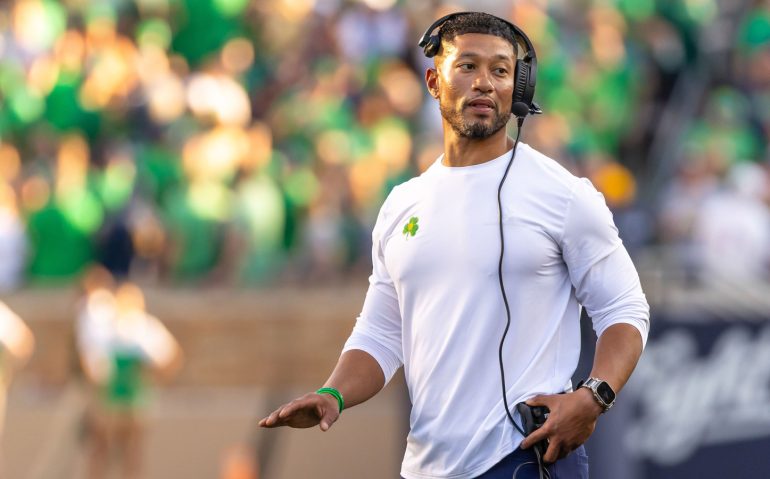 Oct 4, 2025; South Bend, Indiana, USA; Notre Dame head football coach Marcus Freeman adjusts his radio against the Boise State Broncos at Notre Dame Stadium. Mandatory Credit: Michael Caterina-Imagn Images