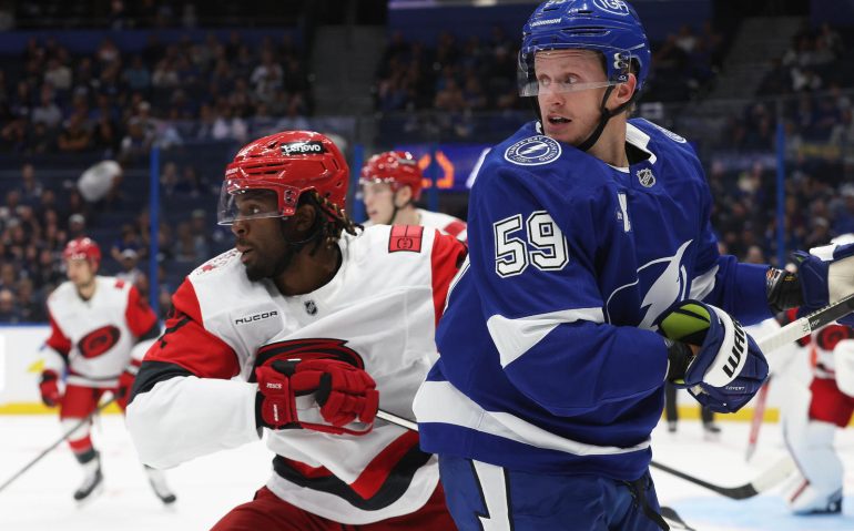 Sep 26, 2025; Tampa, Florida, USA; Carolina Hurricanes right wing Givani Smith (42) and Tampa Bay Lightning center Jake Guentzel (59) during the first period at Benchmark International Arena. Mandatory Credit: Kim Klement Neitzel-Imagn Images