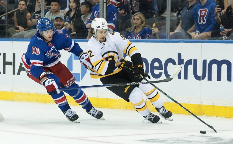 Sep 23, 2025; New York, New York, USA; Boston Bruins center Marat Khusnutdinov (92) plays the puck in front of New York Rangers left wing Will Cuylle (50) during overtime of a preseason game at Madison Square Garden. Mandatory Credit: Vincent Carchietta-Imagn Images