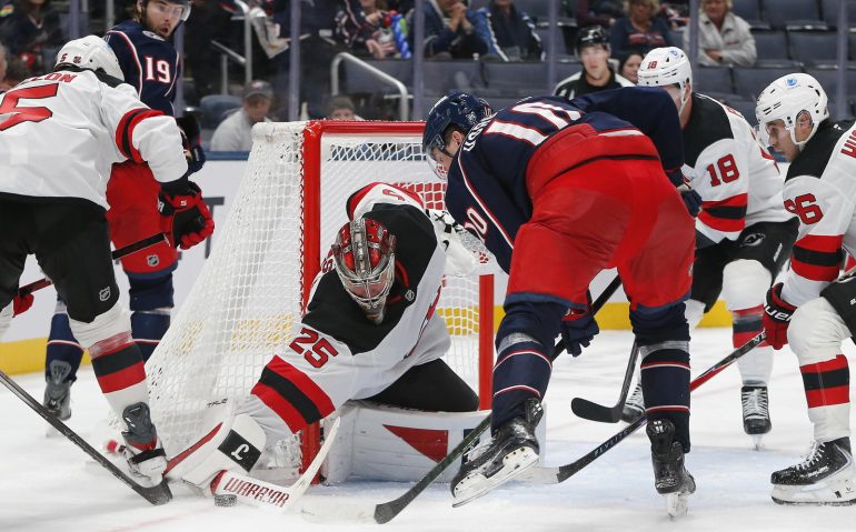 Oct 13, 2025; Columbus, Ohio, USA; New Jersey Devils goalie Jacob Markstrom (25) makes a stick save as Columbus Blue Jackets left wing Dmitri Voronkov (10) looks for a rebound during the third period at Nationwide Arena. Mandatory Credit: Russell LaBounty-Imagn Images