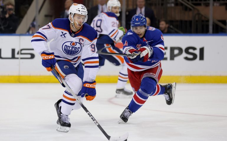 Oct 14, 2025; New York, New York, USA; Edmonton Oilers center Connor McDavid (97) skates with the puck against New York Rangers defenseman Braden Schneider (4) during the second period at Madison Square Garden. Mandatory Credit: Brad Penner-Imagn Images