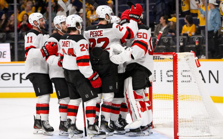 Feb 23, 2025; Nashville, Tennessee, USA;  New Jersey Devils goaltender Nico Daws (50) celebrates the win with his teammates against the Nashville Predators during the third half at Bridgestone Arena. Mandatory Credit: Steve Roberts-Imagn Images